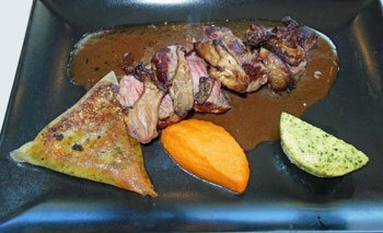 photo of rare beef pieces with vegetable sides